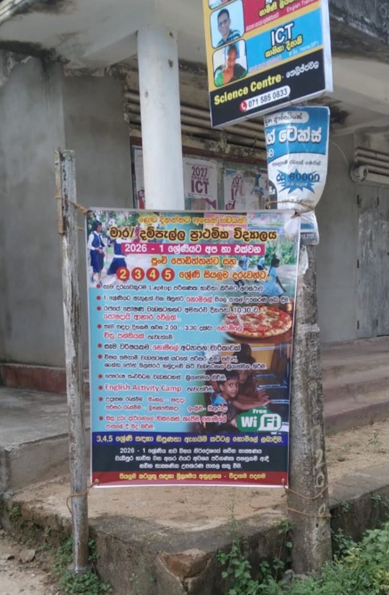 Enrollment banner displayed on a pole outside a building near Dampella