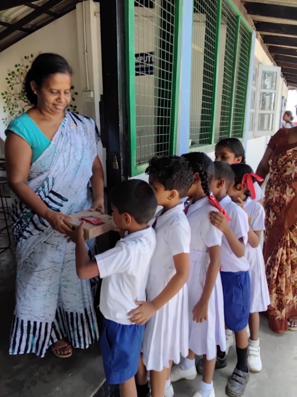 Teacher handing a pizza box to a student